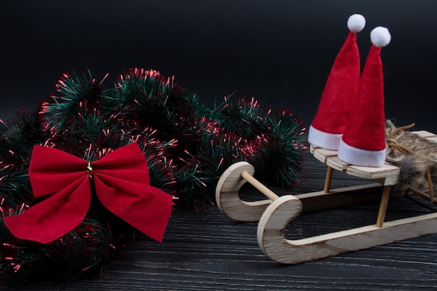 Chapeaux de père Noël sur un traîneau de Noël et un arc de Noël