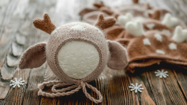 Chapeaux tricotés pour nouveau-nés pour photoshoot studio de Noël pour bébé sur fond de bois agrandi. Conception de vêtements de bébé mignon