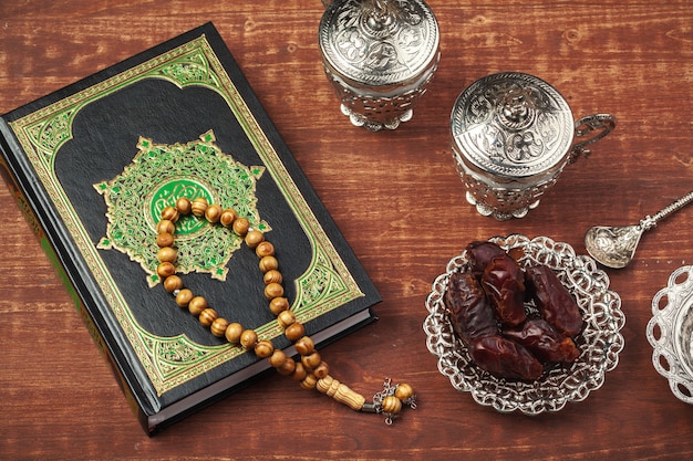 Chapelet de fruits des dattes, de coran et de surface en bois sur la surface en bois pour les musulmans du Ramadan