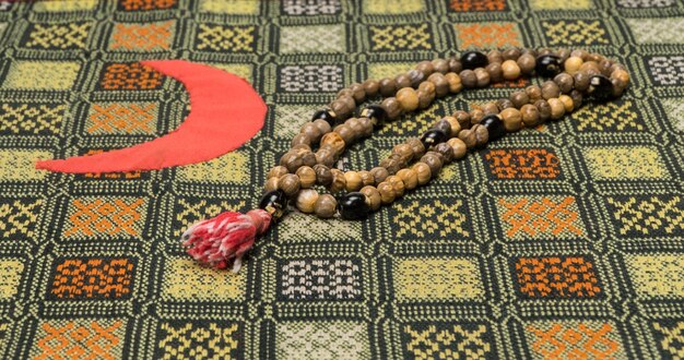 Chapelet musulman sur le tapis de prière avec le symbole du croissant Concepts islamiques et musulmans