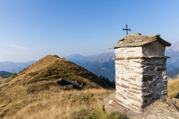 Chapelle chrétienne pendant une journée ensoleillée sur les Alpes italiennes - concept de foi