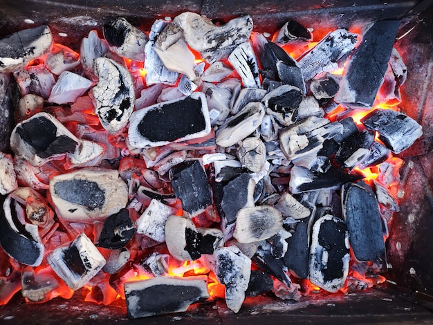 Des charbons ardents et du bois de chauffage sur la grille du gril. Préparation du charbon pour le barbecue sur le gril ouvert. Le concept de détente et d'apprécier la nourriture. Beaux charbons. Charbons prêts pour la cuisson.