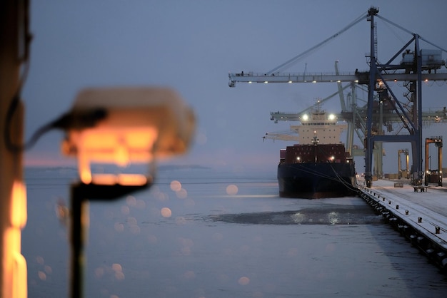 Photo chargement du navire dans le port de commerce international finlandais pendant le froid hivernal enneigé
