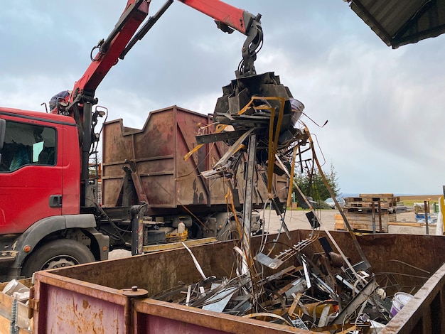 Chargement de ferraille dans un camion Grue de chargement de ferraille de métal rouillé dans le quai Un camion grappin charge de la ferraille industrielle pour le recyclage