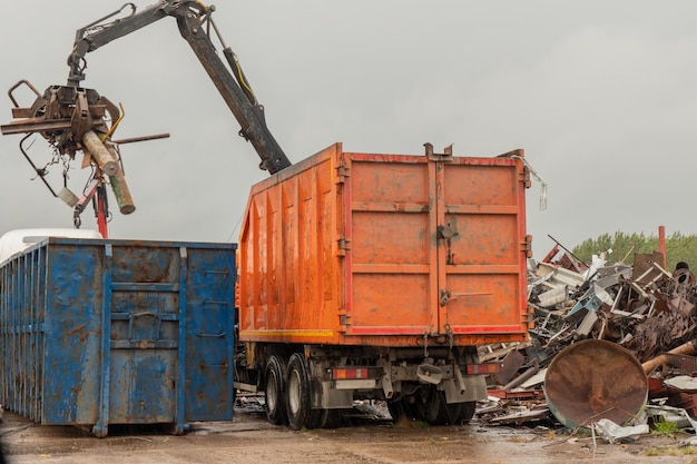 Chargement de ferraille par grue hydraulique, pour recyclage.