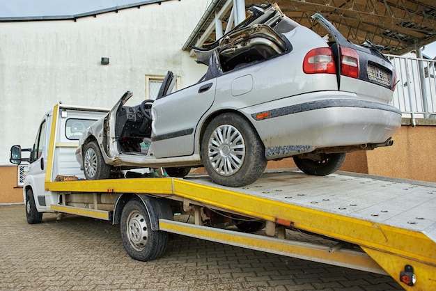 Photo chargement d'une voiture écrasée dans une dépanneuse après un accident de la circulation sur la route