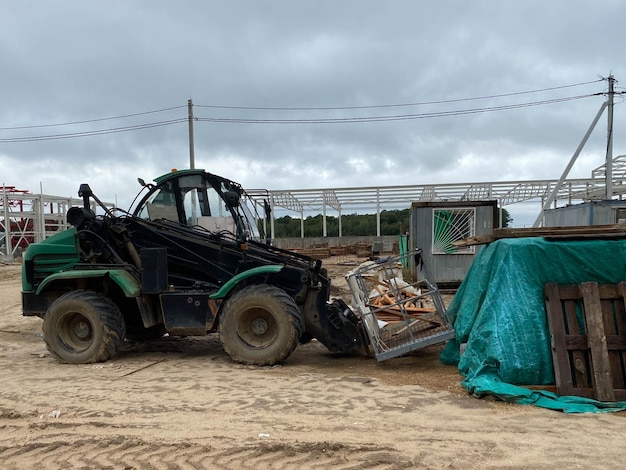 Un chargeur frontal sur un chantier de construction enlève les débris de la collecte de béton armé