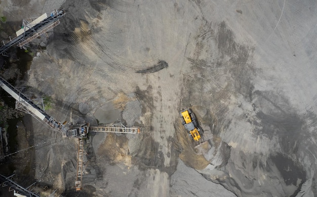 Les chargeurs de sable pelletent des pierres dans des camions à benne basculante