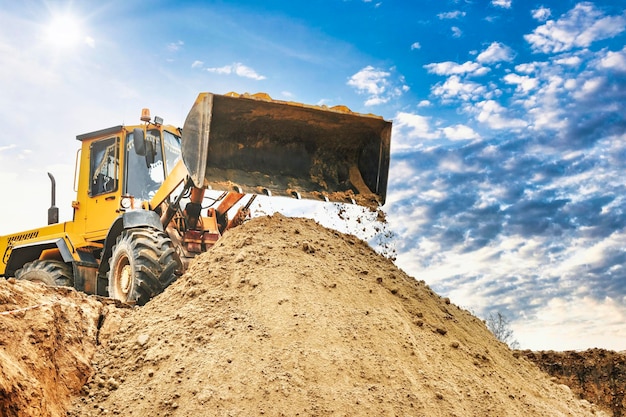 Chargeuse sur pneus ou bulldozer puissant travaillant sur une carrière ou un chantier de construction Gros plan de terrassement Puissant équipement moderne pour les travaux de terrassement