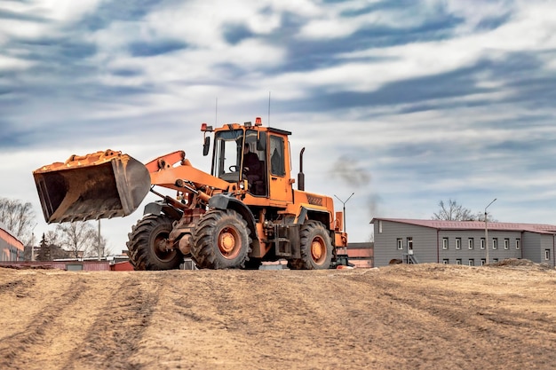 Chargeuse sur pneus ou bulldozer puissant travaillant sur une carrière ou un chantier de construction Gros plan de terrassement Puissant équipement moderne pour les travaux de terrassement