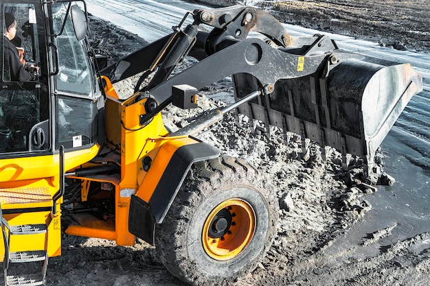 Chargeuse sur pneus ou bulldozer puissant travaillant sur une carrière ou un chantier de construction Terrassement en construction Puissant équipement moderne pour les travaux de terrassement