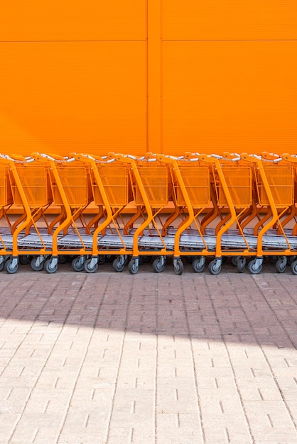 Un chariot d'achat orange empilé à l'entrée.