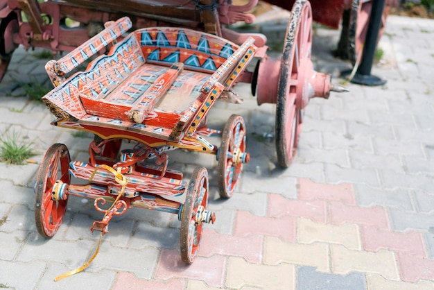 Chariot à jouets en bois rouge et bleu avec un motif sur le trottoir