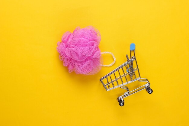 Chariot de supermarché avec éponge de bain sur jaune