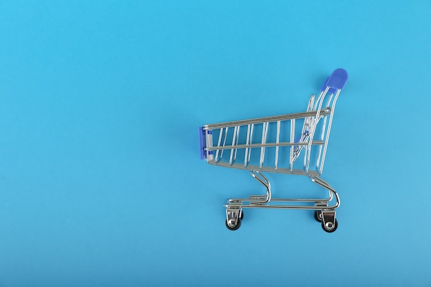 chariot de supermarché est sur fond bleu avec espace copie