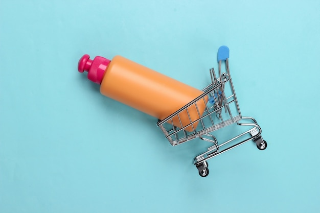 Chariot De Supermarché Mini Avec Bouteille De Shampoing Sur Bleu