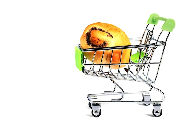 Chariot de supermarché miniature avec un petit pain sur fond blanc
