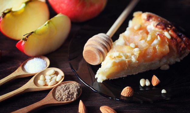 Charlotte aux pommes et noix. Préparation de pomme au four avec des noix et du miel. Dessert pâtisseries à base de pommes et de noix avec du miel sur une table en bois.