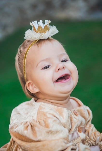 charmant bébé en costume de princesse avec une couronne sur la tête rit