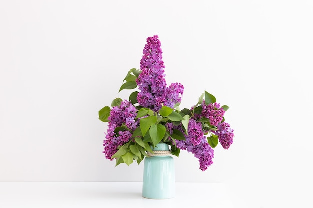 Charmant bouquet de lilas en fleurs dans un vase sur gris