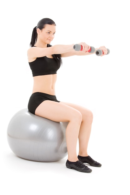 charmant instructeur de fitness avec haltères sur ballon de pilates