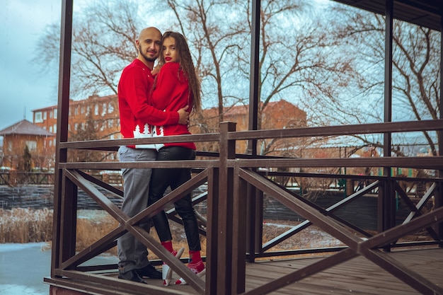 Charmant jeune couple amoureux s'embrasse sur un balcon en hiver. Ambiance de Noël