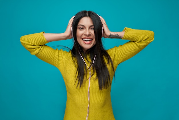 Photo charmant modèle d'écoute de musique avec un casque, souriant.