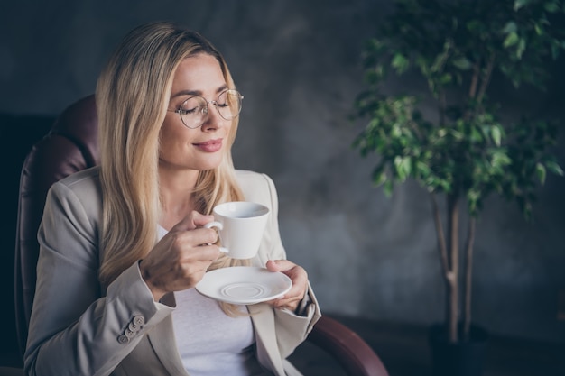 Charmant PDG sucré appréciant une tasse de café dans des lunettes de repos