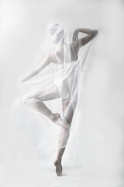 une charmante ballerine en body pose avec un tissu emmêlé comme dans une toile d'araignée