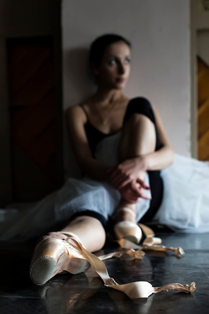 une charmante ballerine dans la classe de danse se réchauffe et répète une performance complètement immer