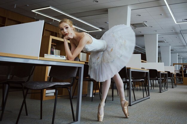 Photo la charmante ballerine est allée à la bibliothèque pour choisir un nouveau livre montrant vos étirements et votre souplesse