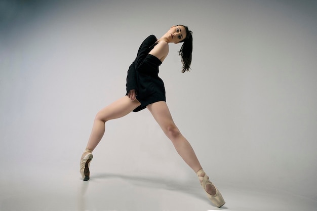 une charmante ballerine improvise dans un studio photo éclaboussant d'émotions