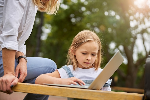 charmante belle enfant de sexe féminin passant du temps avec sa mère à l'extérieur