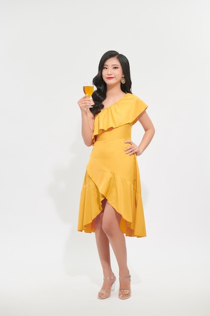 Charmante belle femme avec la main tenir une boisson en verre de vin jaune dans le concept de festival de fête du nouvel an