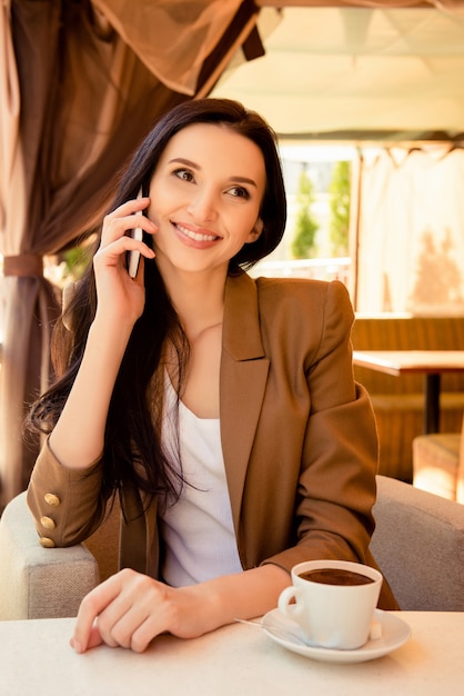 Charmante femme d'affaires assise dans un café