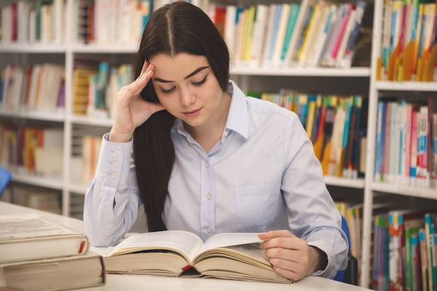 Charmante femme qui étudie à la bibliothèque