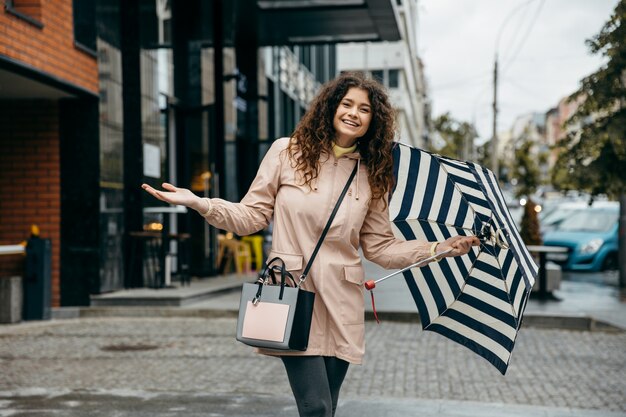 Une charmante femme sous avec parapluie dans la rue