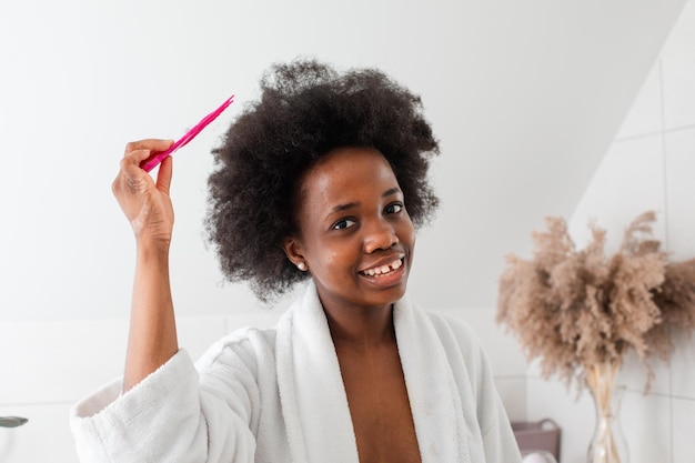 Charmante fille afro-américaine souriante aux cheveux en désordre