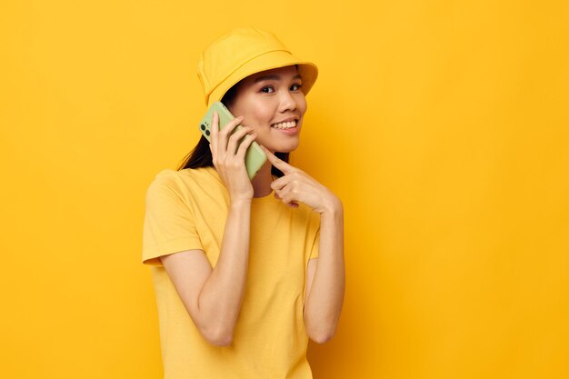 Charmante jeune femme asiatique tenant un téléphone posant un modèle de studio de technologie de style de vie inchangé