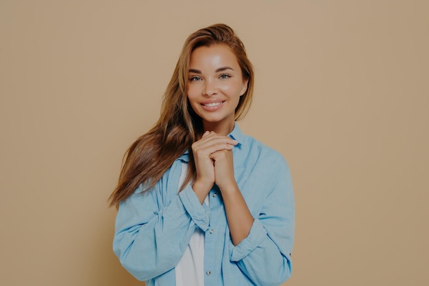 Charmante jeune femme européenne souriante posant devant la caméra en studio