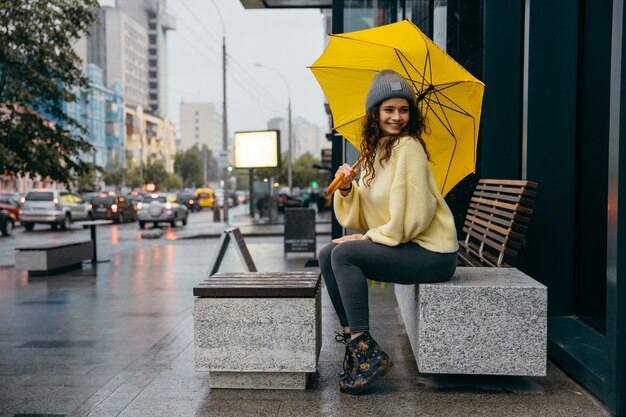 Charmante jeune femme frisée marchant dans la rue