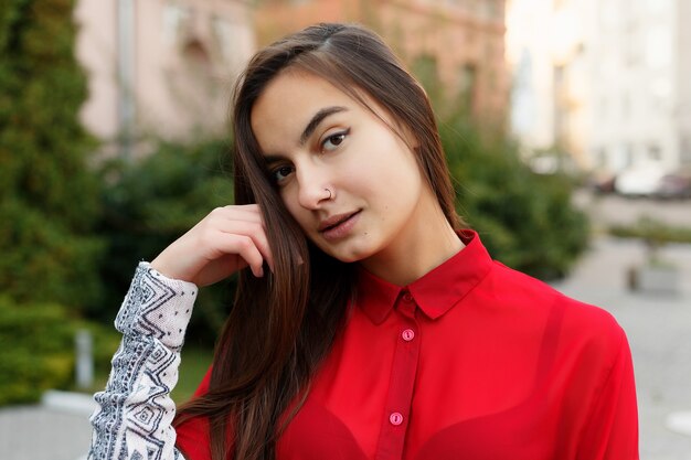 Charmante jeune femme avec de magnifiques cheveux bruns, de grands yeux, un rouge à lèvres rouge magnifique et un look élégant