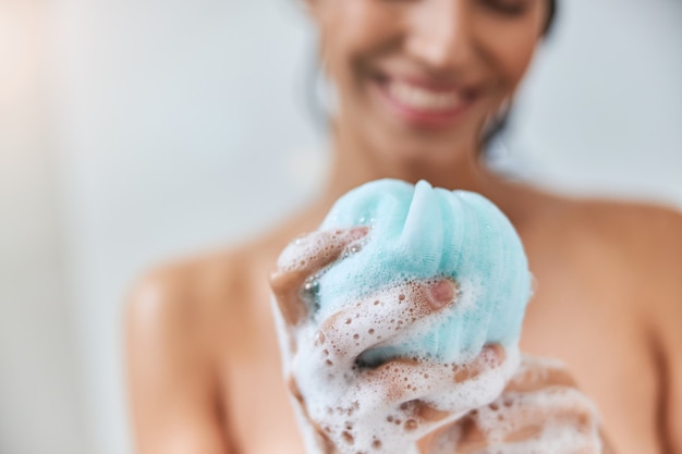 Photo charmante jeune femme tenant une éponge de bain en luffa