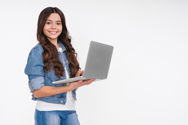 Charmante jeune femme travaillant en freelance à distance du bureau tenant un ordinateur portable tapant un essai universitaire tourner à gauche souriant copier l'espace se tenir fond blanc joyeux naviguer sur le web en utilisant l'ordinateur