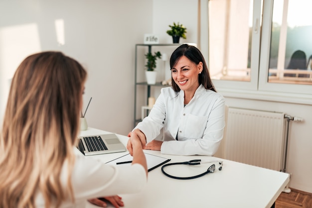 Charmante poignée de main médecin avec un patient.