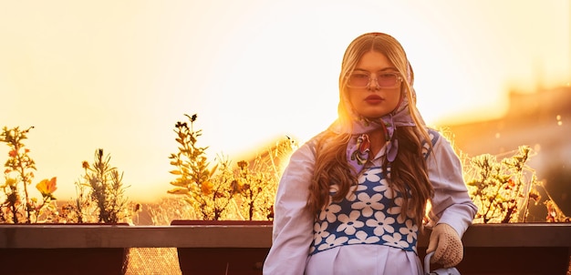 Charme d'une femme parée d'une robe traditionnelle bleue exquise portant un sac à main bleu et un bouque