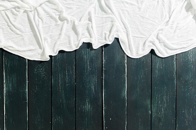 Écharpe blanche sur table en bois noir