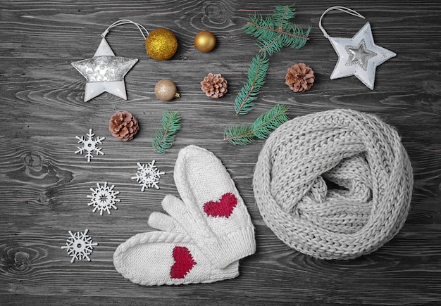 Écharpe tricotée, mitaines et décor de Noël sur une surface en bois