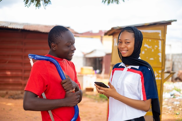 Un charpentier africain local et son client se sentent excités au travail en souriant