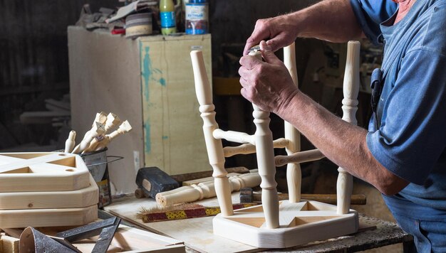 charpentier assemble une chaise en bois sur un établi